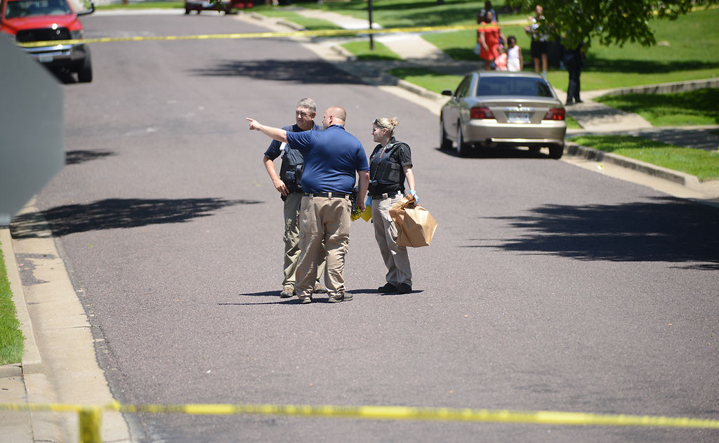 Officers study a crime scene on Anita Court